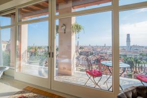 维罗纳Relais Colle San Pietro的客房设有滑动玻璃门,享有城市美景。