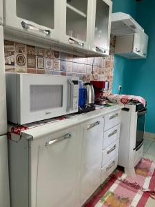 戈亚斯州上帕莱索Cantinho Santiago的厨房配有白色橱柜和微波炉