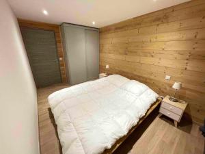 莱索尔Chalet de 5 chambres avec sauna jardin clos et wifi a Les Orres的卧室配有白色的床和木墙