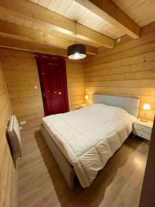 莱索尔Chalet de 5 chambres avec sauna jardin clos et wifi a Les Orres的木制客房内的一间卧室,配有一张床