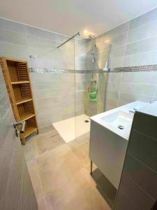 莱索尔Chalet de 5 chambres avec sauna jardin clos et wifi a Les Orres的带淋浴、水槽和玻璃淋浴间的浴室