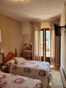 巴鲁尔拉Allotjament rural Casa Milagros的酒店客房设有两张床和窗户。