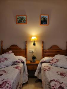 巴鲁尔拉Allotjament rural Casa Milagros的一间卧室设有两张床和一张桌子上的台灯。