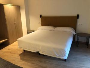 别尔萨HOTEL MONTE PERDIDO的卧室配有一张白色的大床和一张桌子