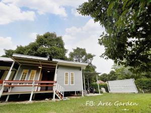 Aree Garden Home Private Homestay by the Waterfall Chantaburi - บ้านสวนพลิ้วอารี ริมธารน้ำตกพลิ้ว จันทบุรี的一座小白色房子,在院子里设有门廊