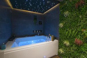 洛里昂Lorient Love Room Le King Size的浴室配有带绿色墙壁的蓝色浴缸