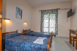 梅松吉ZOI APARTMENS ANTONIS BOTSIS的酒店客房设有两张床和窗户。