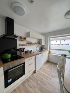 爱丁堡Holyrood Duplex 3- Bedrooms Apartment的厨房配有白色橱柜和炉灶烤箱。