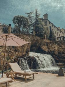 卡尔达斯·德·雷斯托雷多里奥酒店的瀑布旁的桌子和雨伞