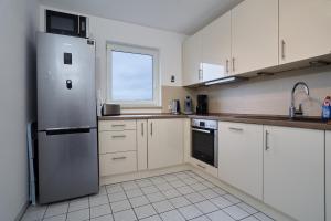 德累斯顿Apartment Sun Balcony Dresden Friedrichstadt的厨房配有白色橱柜和不锈钢冰箱