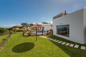 科拉雷斯BeGuest SunRoca Suites的一个带遮阳伞和游泳池的庭院