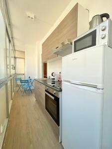 巴里BARIROOMS - Melo Suites的厨房配有白色冰箱和炉灶。