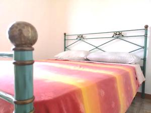 San MicheleEco House San Michele的一张带金属框架和彩色毯子的床