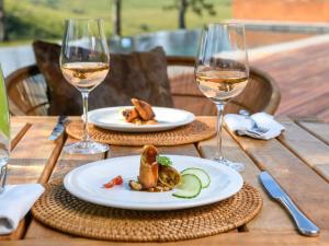 埃斯特科特Zulu Waters Game Reserve的木桌,带两盘食物和酒杯