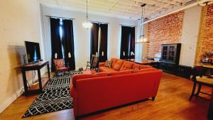林奇堡Family-Friendly 3 bedroom in Historic building!的客厅设有红色沙发和砖墙