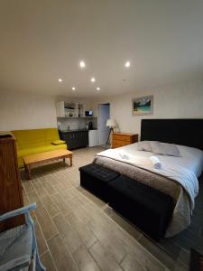圣乔治-德迪多讷查塔旅馆的一间卧室设有一张大床和一张黄色长凳
