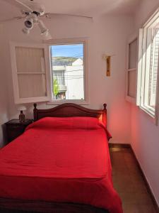 维拉卡洛斯帕兹Blau Hostel的窗户客房内的一张红色的床