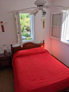 维拉卡洛斯帕兹Blau Hostel的卧室内的一张红色的床,卧室设有窗户