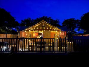 滕比Jungle Book Safari Tent的夜晚有圣诞灯的房子