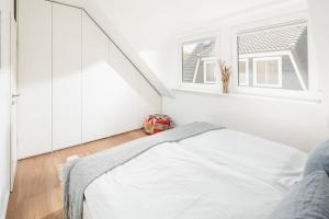 诺德奈Stewohood Norderney的白色的卧室设有床和窗户