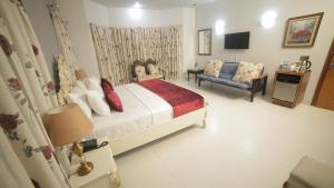 卡拉奇Four Squares Karachi的一间卧室配有一张床、一张沙发和一台电视