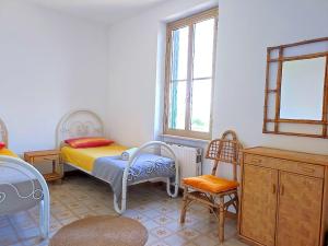 San MicheleEco House San Michele的一间卧室配有一张床、一把椅子和窗户。