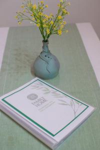 夸尔图-圣埃莱娜Family Home的坐在桌子上的书,花瓶