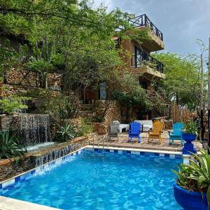 圣玛尔塔Akela Gaira Hotel的一座带喷泉的房屋前的游泳池