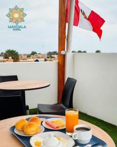 皮斯科Mandala的一张桌子,上面有早餐食品和橙汁
