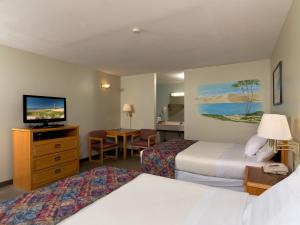 米尔斯Sierra Sands Family Lodge的酒店客房设有两张床和一台平面电视。