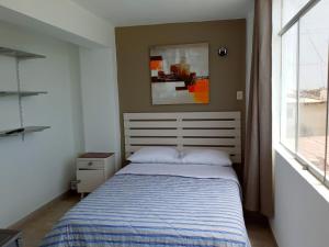 万查科Hospedaje Nuna - Playa Huanchaco的一间卧室设有一张床和一个窗口