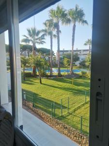 埃尔波提尔Adosado de lujo en El Portil Playa y Golf的从棕榈树公园的窗户欣赏美景