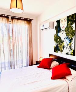 拉纳卡BALI SUITES 101的一间卧室配有一张带两个红色枕头的床