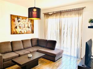 拉纳卡BALI SUITES 101的客厅配有棕色沙发和桌子