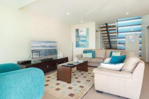 福斯特Strand Beachside 1003 Penthouse的客厅配有两张沙发和一张桌子