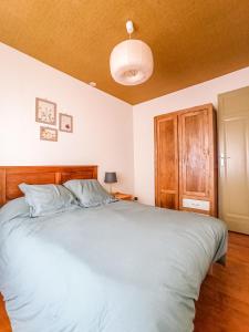 热德尔Maison de montagne proche Gavarnie 12-14 personnes的一间卧室配有一张大床和木制床头板
