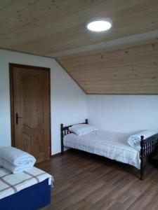 新瓦罗什Apartman Teodora Uvac的配有木天花板的客房内的两张床