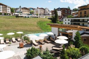 瑟弗浩斯Hotel & Garni Das Köhle - inklusive der SUPER SOMMER CARD IM SOMMER 2024的酒店设有带椅子和遮阳伞的屋顶露台