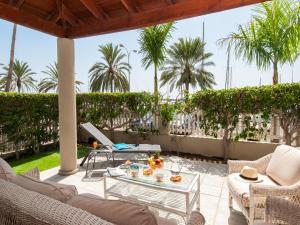 帕斯托布兰克滨海豪华简易别墅的一个带桌椅和棕榈树的庭院