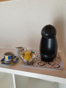 萨斯格伦德Haus Artemis的盘子上的一个咖啡壶,放在桌子上