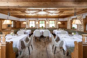 阿尔卑巴赫Der Böglerhof - pure nature spa resort的一间设有白色桌椅的用餐室