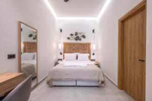 罗希姆诺Marea Boutique Suites的一间卧室配有一张床和一面大镜子