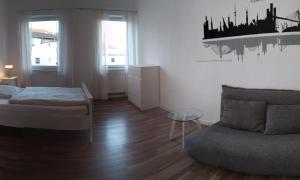 锡格堡Siegburg Apartment 1的一间卧室配有一张床、一张沙发和一把椅子