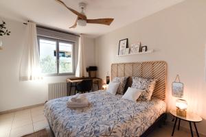 图卢兹Guilhermy - Maison contemporaine avec jardin的一间卧室配有一张带蓝色棉被的床和窗户。