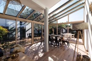 图卢兹Guilhermy - Maison contemporaine avec jardin的温室设有玻璃墙和桌椅