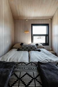 Sandgerði桑德格迪小屋酒店的一间小房间的卧室,配有一张床铺