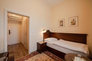 乌赫尔堡格兰德酒店的卧室配有一张床和一张桌子及椅子