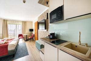 赫维兹假日俱乐部酒店的客房设有一张床和一个带水槽的厨房