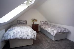 CreggansCreggans Cottage的阁楼卧室设有两张床和窗户。