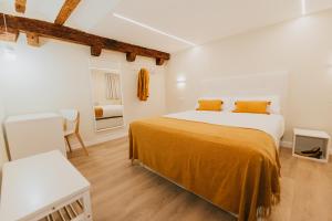 布尔戈斯Apartamentos BURGOSUITES的一间卧室配有一张带橙色床单的大床
